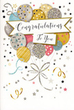 The photograph features an elegant, celebratory congratulations card, set upright so its front design is clearly visible. The artwork is dominated by a delightful bunch of helium-style balloons, illustrated as though they are lifting gracefully into the air. The balloons are rendered in sophisticated tones of champagne gold, muted silver, pastel blue, blush pink, and soft dove grey, each enhanced with fine detailing-striped bands, tiny star patterns, and subtle glitter that gives a gentle shimmer, much like sunlight glancing off the Thames near Putney Pier. From a single gathering point at the base, the balloon strings sweep upwards, uniting the cluster into one cohesive, festive image. Across the centre floats a gently curved banner, proudly displaying the words Congratulations To You in flowing, decorative script that conveys warmth, admiration, and genuine delight. Around this central composition, small metallic stars, swirling ribbons, and scattered confetti shapes are sprinkled across a light, uncluttered background, evoking the atmosphere of a party in full swing-perhaps a graduation celebration near Putney High Street or a promotion toast in a local riverside restaurant. The card's colour palette and gentle shine make it versatile enough to accompany both vibrant mixed bouquets and more understated arrangements. Seen through the eyes of an experienced florist, this design is perfect for those special milestones where customers in SW15 want to send heartfelt praise along with their flowers, ensuring the recipient feels truly celebrated and supported in their success, whether it's a first job, a long-awaited qualification, or any proud moment worth remembering.