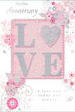 The anniversary card here is a gentle tribute to lasting romance, styled with soft pastel pinks and silvery greys that echo the calm tones of Putney's riverside at dusk. At the centre, the word LOVE appears in slightly raised, glittering letters, their edges catching the light. The O is transformed into a shimmering silver heart, its textured surface reminiscent of a tiny polished keepsake, giving the card a focal point that feels both playful and deeply sentimental. Around this, a garland of delicate blossoms unfurls in blush and mauve, their petals fading at the tips in a watercolour softness that suggests freshly opened blooms. The flowers are accompanied by fine, flowing lines that loop and curl like vines, reflecting the same thoughtful movement a florist's hand might create when arranging stems in a vase. Small details-petal-like shapes, elegant swirls, and subtle butterflies-are scattered through the design, adding a quiet sense of motion, as though a gentle breeze from the Thames is passing through. The background is a muted wash of pink and white, providing a serene contrast to the more intricate illustration. Above and below, phrases such as On Our Anniversary and I love you today and always are written in graceful, understated script, lending the design a voice that feels authentic rather than grandiose. Like a carefully chosen bouquet delivered across SW15, this card captures a private, treasured moment between two people, soft-spoken yet deeply heartfelt, perfect for honouring the shared journey of a Putney couple year after year.